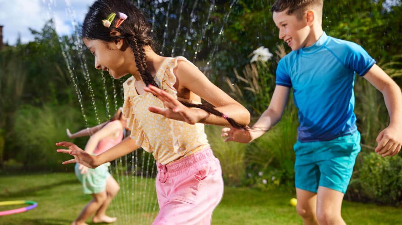 Image of kids playing in the garden with water.